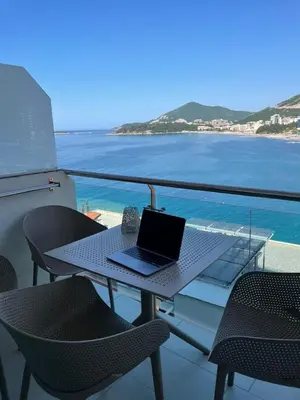 a laptop on a table on a balcony with the ocean at Workation Panorama Escape in Budva