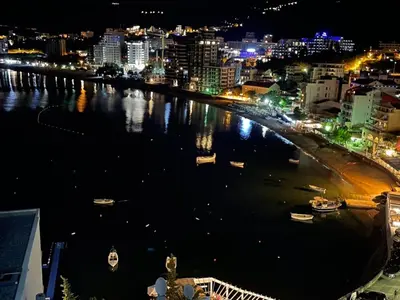 a city at night with boats in the water at Workation Panorama Escape in Budva
