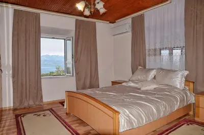 a bedroom with a bed and a large window at house for rent 