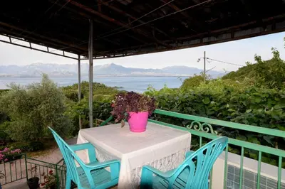 a table with two chairs and a pink vase on it at house for rent 