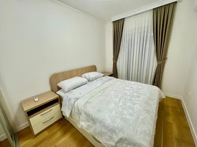 a small bedroom with a bed and a night stand at Central City Lux Apartments in Podgorica