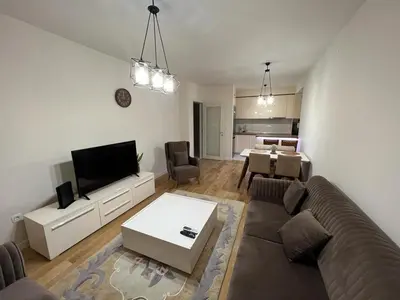 a living room with a couch and a tv and a table at Central City Lux Apartments in Podgorica