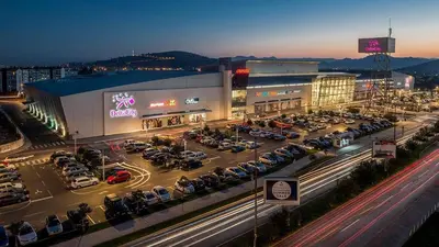 a parking lot with cars parked in front of a building at Central City Lux Apartments in Podgorica