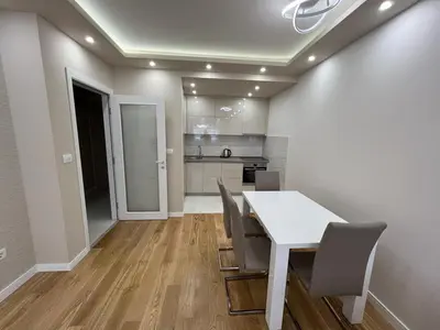 a kitchen and dining room with a white table and chairs at Central City Lux Apartments in Podgorica