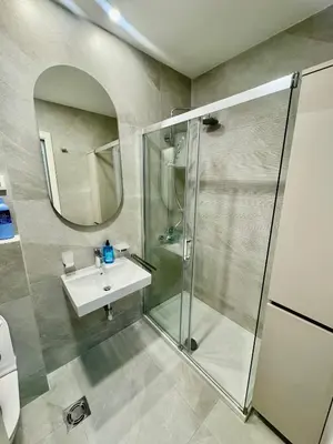 a bathroom with a shower and a sink and a mirror at Central City Lux Apartments in Podgorica