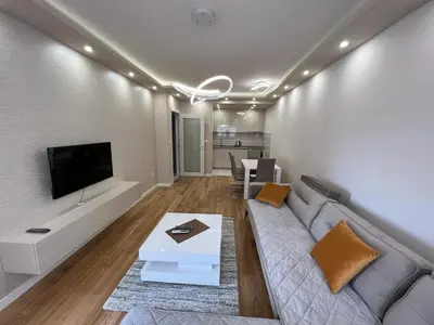 a living room with a couch and a tv at Central City Lux Apartments in Podgorica