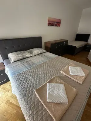 a bedroom with a large bed with two towels on it at Apartman Jedro Lux in Rafailovici