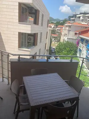 a table and chairs on the balcony of a building at Apartman Jedro Lux in Rafailovici