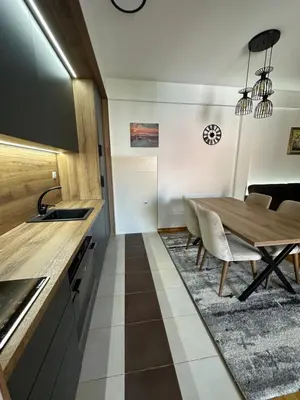 a kitchen and dining room with a wooden table and chairs at Apartman Jedro Lux in Rafailovici