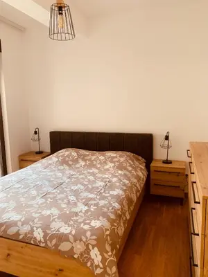 a bedroom with a bed and a desk with two lamps at Apartman Jedro Lux in Rafailovici