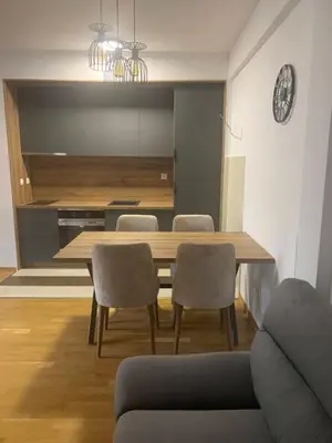 a kitchen and dining room with a wooden table and chairs at Apartman Jedro Lux in Rafailovici