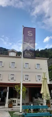 a hotel with a sign in front of a building at Hotel S Family Jovicevic in Rijeka Crnojevića