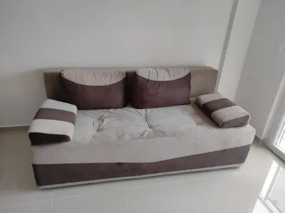 a couch with two pillows on it in a room at Apartman Centar Bar in Bar