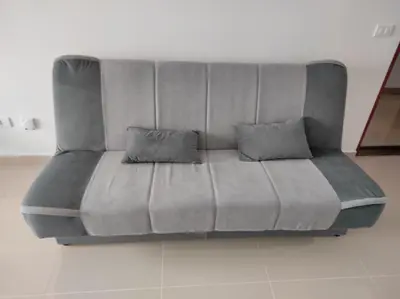 a gray couch with two pillows on a floor at Apartman Centar Bar in Bar
