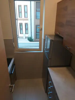a small kitchen with a window and a refrigerator at Apartment Joković in Budva