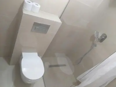 a white bathroom with a toilet and a shower at Apartment Joković in Budva
