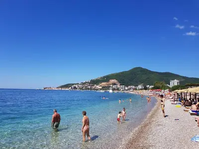 a group of people on a beach in the water at Apartment Joković in Budva
