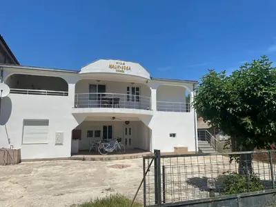 a white building with a bike parked in front of it at Vila Goga in Ulcinj