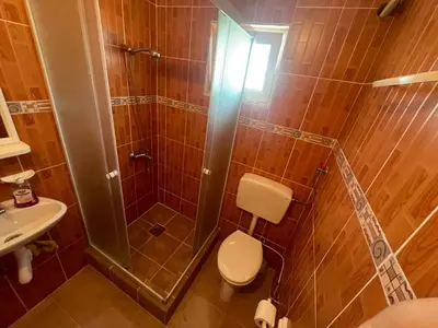 a bathroom with a shower and a toilet and a sink at Vila Goga in Ulcinj