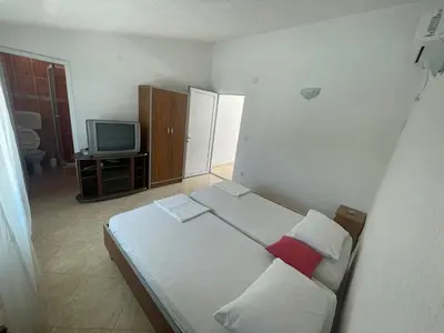 a small bedroom with a bed and a television at Vila Goga in Ulcinj