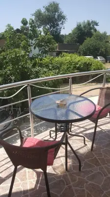 a glass table and two chairs on a patio at Vila Goga in Ulcinj