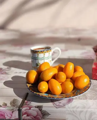 a plate of oranges on a table with a cup at DIKA Apartment in Bar