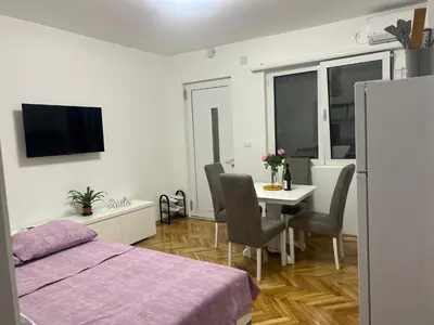 a bedroom with a bed and a table with chairs at DIKA Apartment in Bar