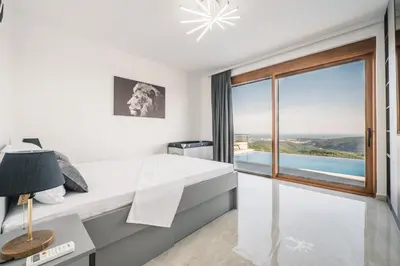 a bedroom with a desk and a large window at Vila katune 2022 in Ulcinj