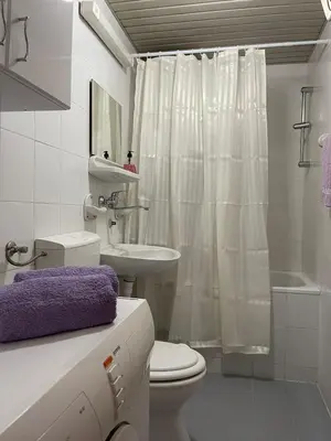 a white bathroom with a toilet and a sink at Carpe diem in Bar