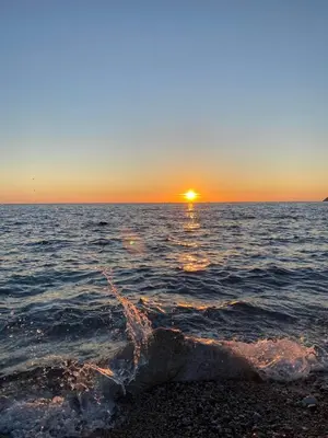 a sunset over the ocean with the sun setting at Carpe diem in Bar