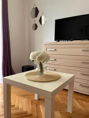 a white coffee table with a vase of flowers on it at Carpe diem in Bar
