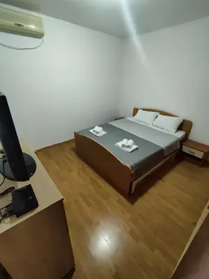 a bedroom with a bed and a desk with a computer at Apartmani Bellami in Becici