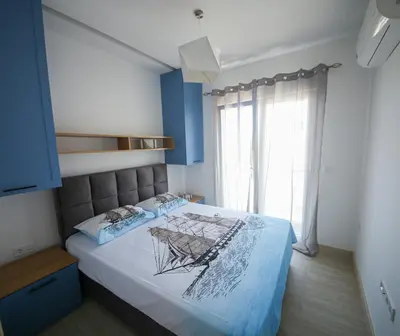 a bedroom with a bed with blue walls and a window at Luxury Mare apartment in Bar