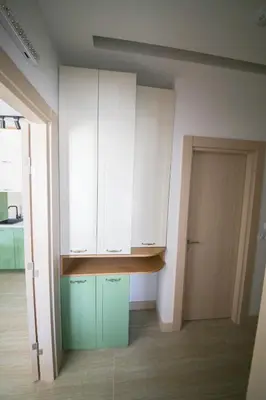 a kitchen with green and white cabinets and a door at Luxury Mare apartment in Bar