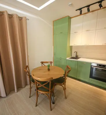 a small kitchen with a wooden table and chairs at Luxury Mare apartment in Bar