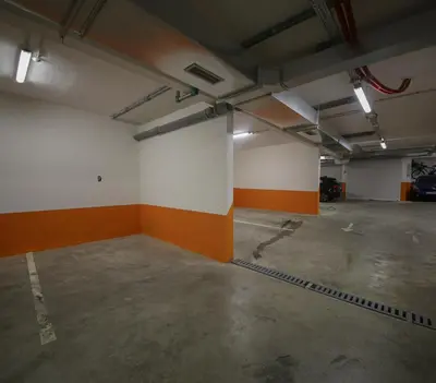 an empty parking garage with orange and white walls at Luxury Mare apartment in Bar
