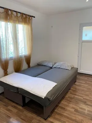 a bedroom with a large bed with a window at Apartmani LALA 2 Canj in Čanj