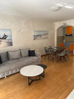 a living room with a couch and a table at Seashell Hideaway Apartment in Pržno