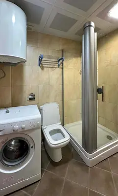 a bathroom with a washing machine and a toilet at Seashell Hideaway Apartment in Pržno