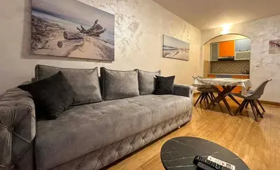 a living room with a couch and a table at Seashell Hideaway Apartment in Pržno