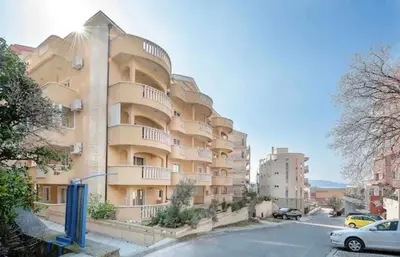 a large apartment building on the side of a street at Seashell Hideaway Apartment in Pržno