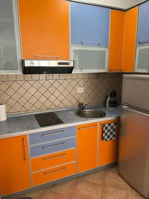 a kitchen with orange cabinets and a sink at Seashell Hideaway Apartment in Pržno