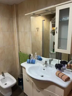 a bathroom with a white sink and a toilet at Seashell Hideaway Apartment in Pržno
