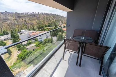 a table and chairs in a room with a large window at N Hotel in Sutomore
