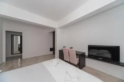 a white room with two chairs and a flat screen tv at N Hotel in Sutomore