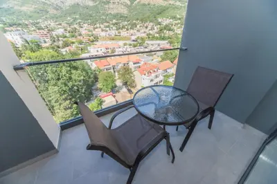 a table and chairs on a balcony with a view at N Hotel in Sutomore