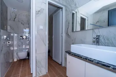 a white bathroom with a sink and a toilet at N Hotel in Sutomore