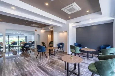 a waiting room with tables and chairs at N Hotel in Sutomore
