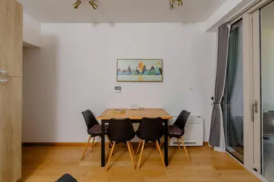 a dining room with a wooden table and chairs at City Apartments 2 in Budva
