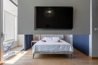 a bedroom with a bed with a flat screen tv on the wall at City Apartments 2 in Budva